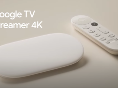 Le nouveau Google TV Streamer posé sur un meuble TV à côté de sa télécommande