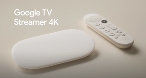 Le nouveau Google TV Streamer posé sur un meuble TV à côté de sa télécommande